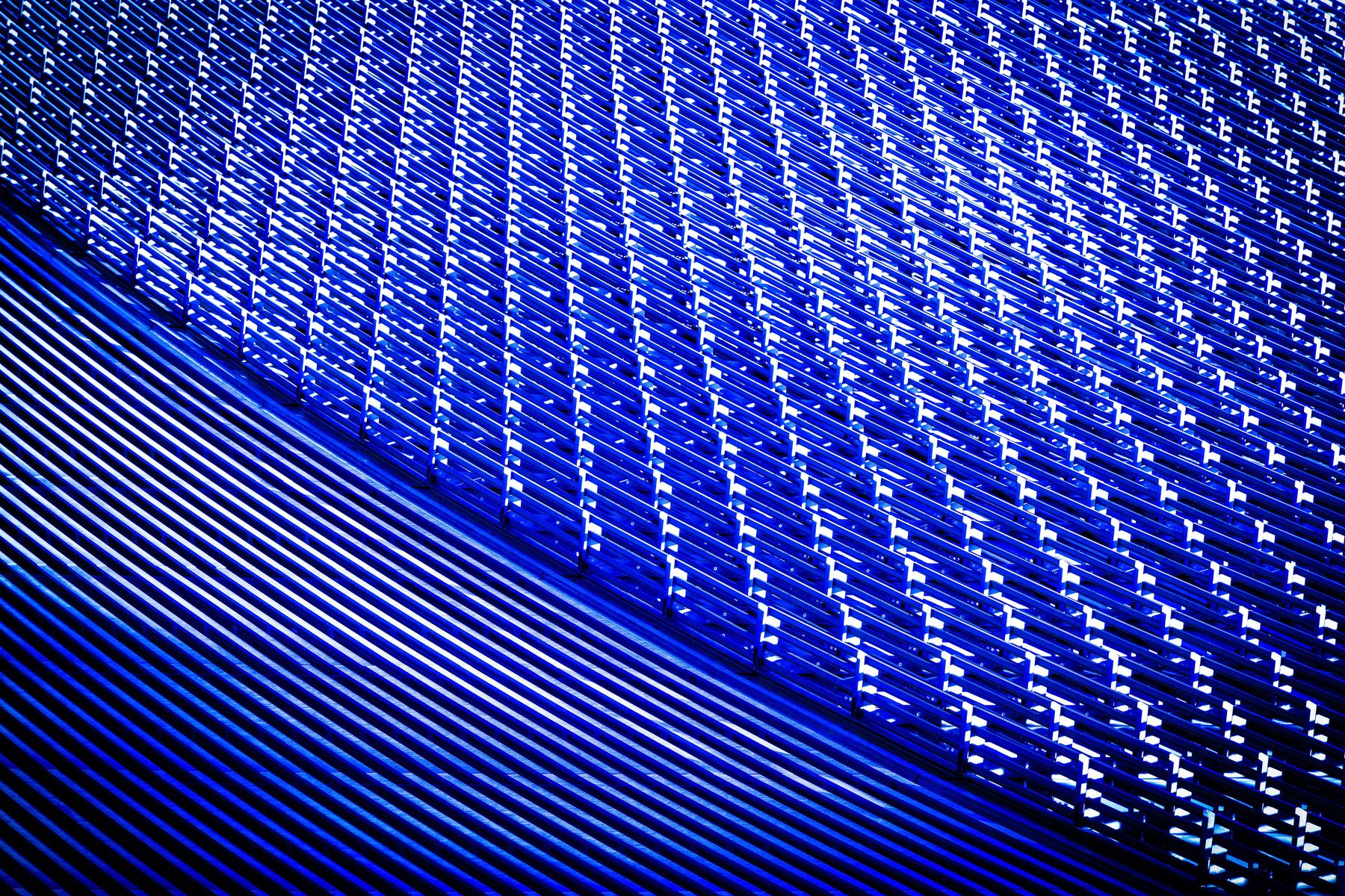 Close-up of illuminated blue architectural slats, seen at an angle